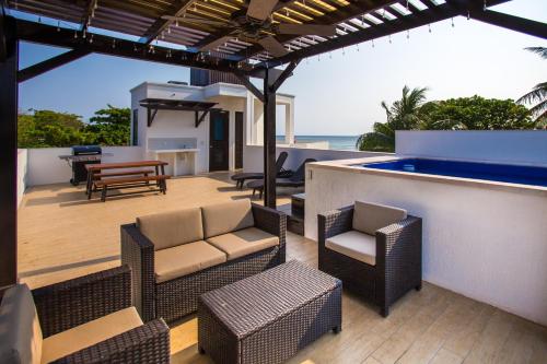 a patio with chairs and a bar with the ocean at Bella Luna Beach Condo #227487 in West End