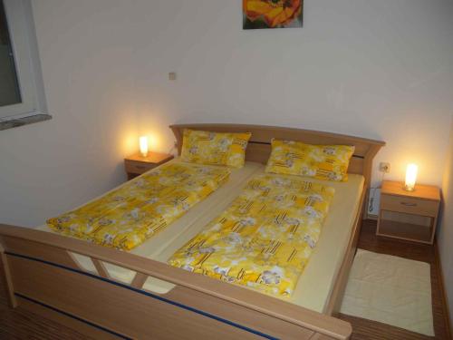um quarto com duas camas com lençóis amarelos e duas velas em Apartment Liznjan 5 em Ližnjan