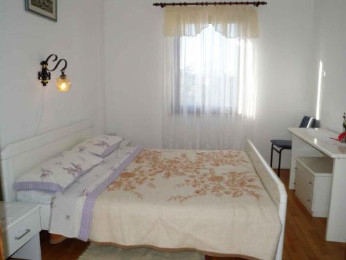 a white bedroom with a bed and a window at Holiday home in Premantura - Istrien 10653 in Premantura