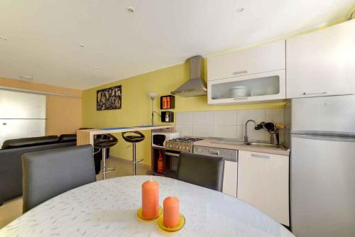 a kitchen with a table and chairs and a kitchen with a counter at Apartment Pula 15 in Vintijan