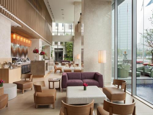 a lobby with a couch and tables and chairs at Millennium Hotel Taichung in Taichung