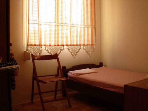 a bedroom with a bed and a chair and a window at Apartment Zlarin 1 in Zlarin