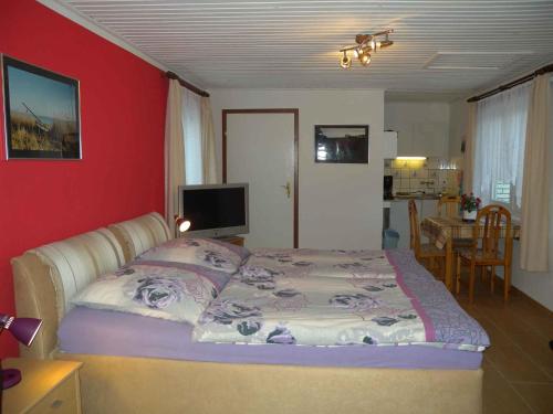 een slaapkamer met een bed met een rode muur bij Holiday home in Bergen auf Rügen 2852 in Bergen auf Rügen