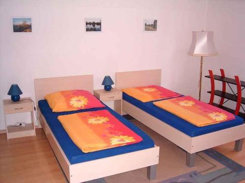 2 Betten in einem Zimmer mit 2 Stühlen und einer Lampe in der Unterkunft Apartment in Küstriner Vorland 2607 in Manschnow