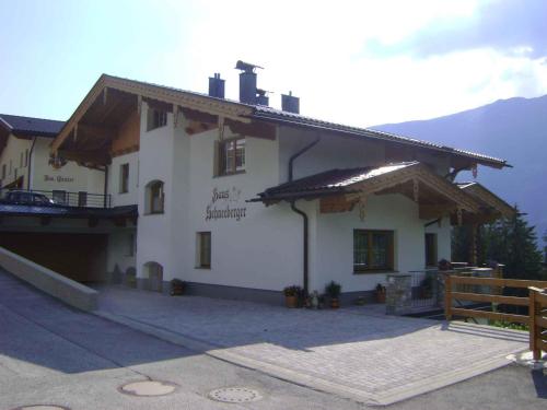 a large white building with a balcony and mountains at Apartment Zell am Ziller 2 in Zell am Ziller