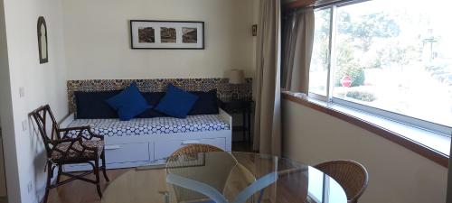 a room with a table and a bench with blue pillows at Suites Foz O Porto in Porto