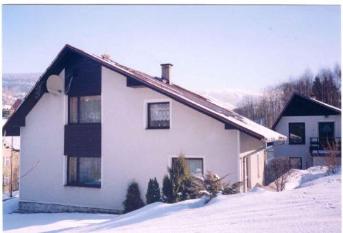 a white house with snow in front of it at Apartment in Rokytnice nad Jizerou 2102 in Rokytnice nad Jizerou