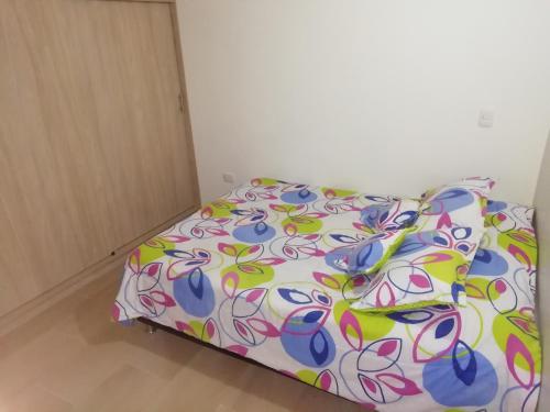 a bedroom with a bed with a colorful comforter at Apartamento La Ceja in La Ceja