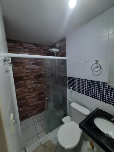 a bathroom with a shower and a toilet and a sink at Casa proximo a praia in Paulista