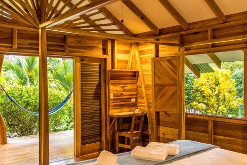 a room with a bed and a large window at Relax Natural Village Adults Only in Puerto Viejo