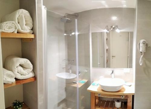 a bathroom with a shower and a sink and towels at CONDOR STUDIO BARILOCHE in San Carlos de Bariloche