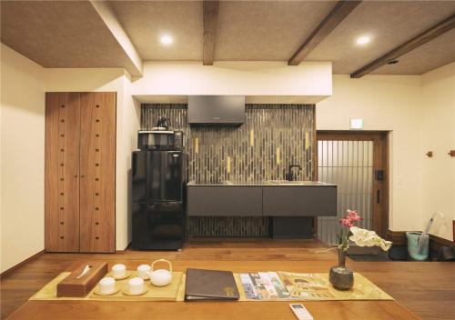 a kitchen with a black refrigerator and a table at 谷町君・星屋・城下の宿 in Kyoto