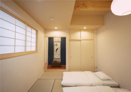 a room with two beds and a window at 谷町君・星屋・城下の宿 in Kyoto