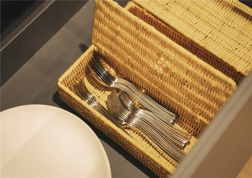 a pair of forks in a basket next to a toilet at 谷町君・星屋・城下の宿 in Kyoto
