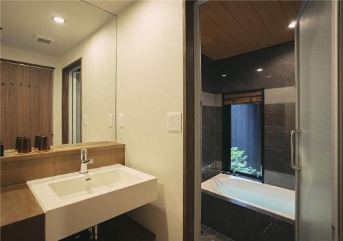 a bathroom with a sink and a bath tub at 谷町君・星屋・城下の宿 in Kyoto