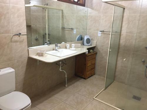 a bathroom with a sink and a shower and a toilet at CASARÃO DA CASCATA in Gramado