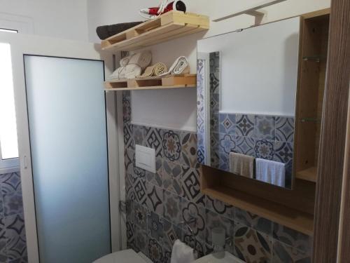 a bathroom with a mirror and a toilet and towels at Casa Veronica in Marzamemi