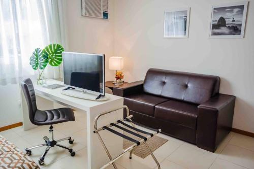 a room with a desk with a computer and a leather couch at Flat Completo para uma estadia perfeita NOTA FISCAL in Campos dos Goytacazes