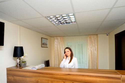 a woman talking on a cell phone in a room at Podolski Hostel in Kyiv