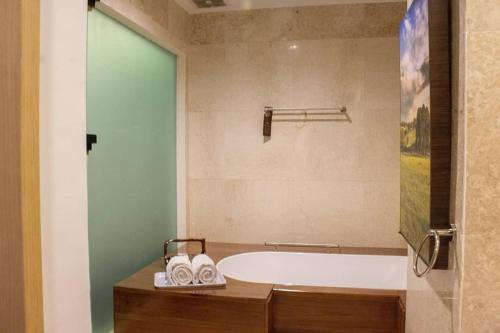 y baño con bañera y lavamanos. en Kyriad Arra Hotel Cepu, en Cepu