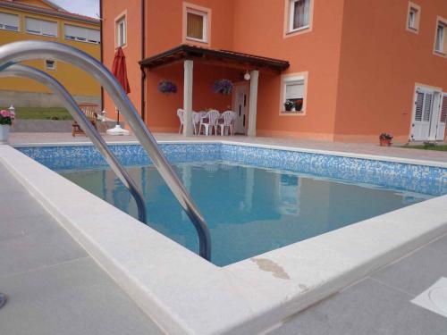 a swimming pool in front of a house at Apartment Kastel 22 in Kaštel