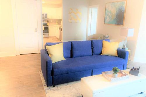 a blue couch in a living room with a table at Buckhead Blue - Spacious 2 bd 2ba - Private Balcony-Rooftop- S13 in Atlanta