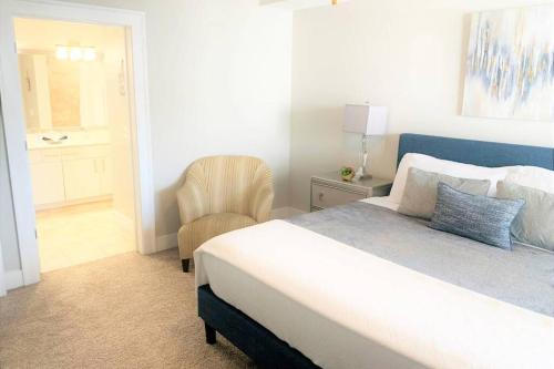 a bedroom with a large bed and a chair at Buckhead Blue - Spacious 2 bd 2ba - Private Balcony-Rooftop- S13 in Atlanta