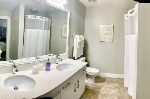 a bathroom with two sinks and a toilet and a mirror at Buckhead Blue - Spacious 2 bd 2ba - Private Balcony-Rooftop- S13 in Atlanta