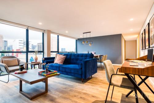 a living room with a blue couch and a table at ULIV Luxe Apartments Polanco in Mexico City
