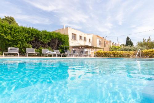 una gran piscina con sillas y una casa en Villa Caleta - Costa CarpeDiem en Calpe