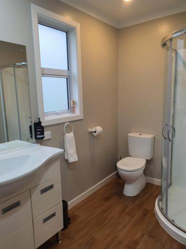 een badkamer met een toilet en een glazen douche bij Outback on Broadway in Picton