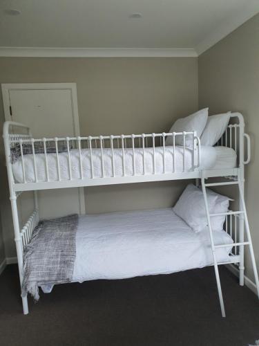 a white bunk bed in a room with pillows at Outback on Broadway in Picton