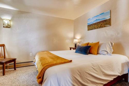 a bedroom with a large white bed and a chair at Hot Tub & Sauna PEAK 8 BRECKENRIDGE in Breckenridge