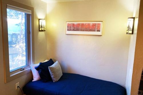 a bedroom with a blue bed and a window at Hot Tub & Sauna PEAK 8 BRECKENRIDGE in Breckenridge