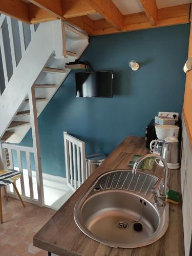 una cocina con fregadero y una escalera en L'Anse Noire, en Saint-Valery-sur-Somme