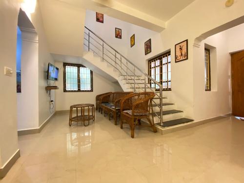 a living room with a staircase and a table and chairs at Le Royce Villa - TIE Hotels & Resorts in Puducherry