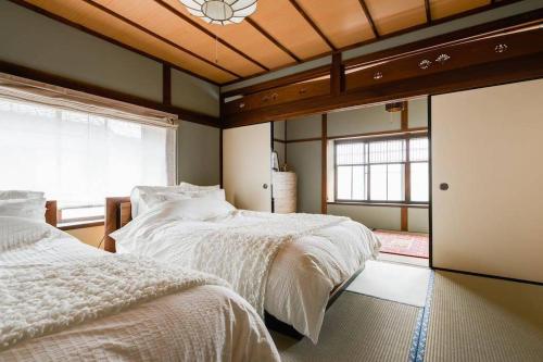a bedroom with two beds and a window at Shikano Resort in Nara