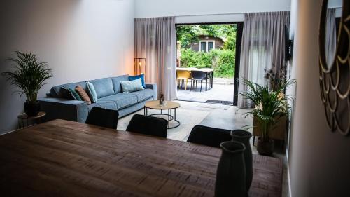 a living room with a couch and a table at Welcome in - Oranjezon - Vakantiehuis 6 personen in Vrouwenpolder