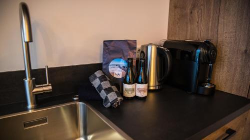 a kitchen counter with two bottles of wine next to a coffee maker at Welcome in - Oranjezon - Vakantiehuis 6 personen in Vrouwenpolder