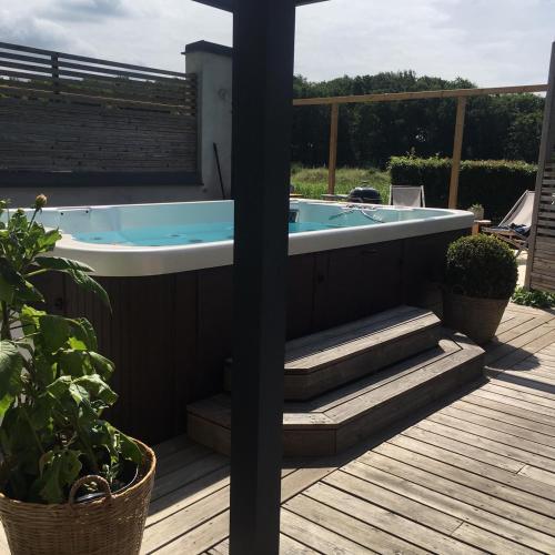 a jacuzzi tub on the deck of a house at Glamping i Döshult in Viken