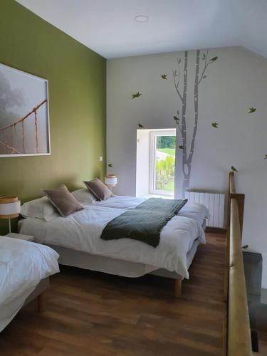 a bedroom with two beds and a tree on the wall at Gite La Buissonnière in Villemoirieu
