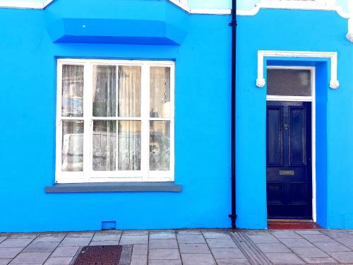 a blue building with a window and a blue door at 52 Cambrian St in Aberystwyth