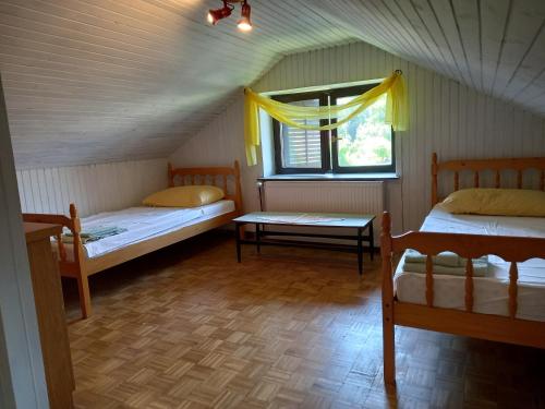 Gornja BistricaにあるCountry House Alešのベッド2台と窓が備わる客室です。
