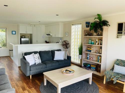 Una sala de estar con un sofá y una mesa de café. en The Esplanade Holiday Home, en Indented Head