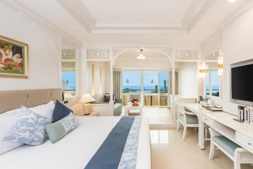 a bedroom with a bed and a desk with a television at Royal Cliff Beach Hotel Pattaya in Pattaya South