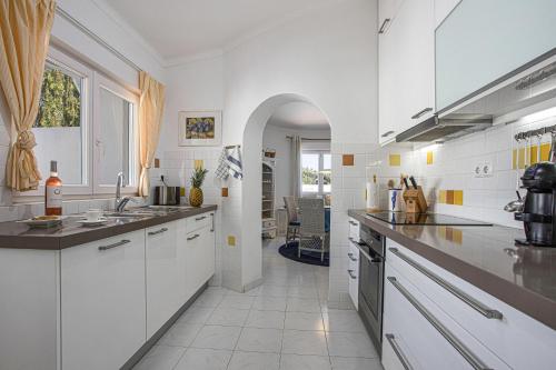 a white kitchen with a sink and a counter at Villa Sagres in Portimão