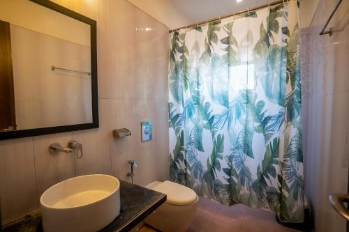 a bathroom with a toilet and a shower curtain at Hotel New Panchratna in Ahmadnagar