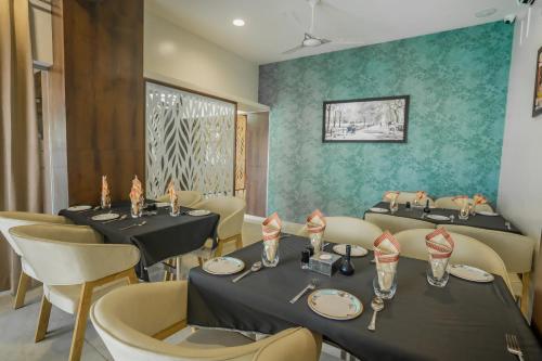 a dining room with two tables and chairs at Hotel New Panchratna in Ahmadnagar