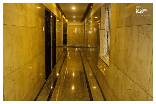 an empty hallway of a building with a shiny floor at hotel church park in Velānganni