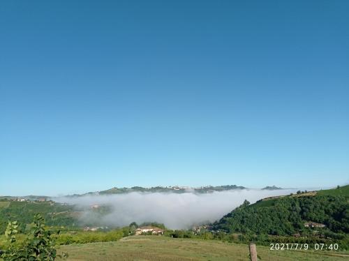 a foggy valley in the mountains with a house at LA CASA DEI MASUE' in Alba